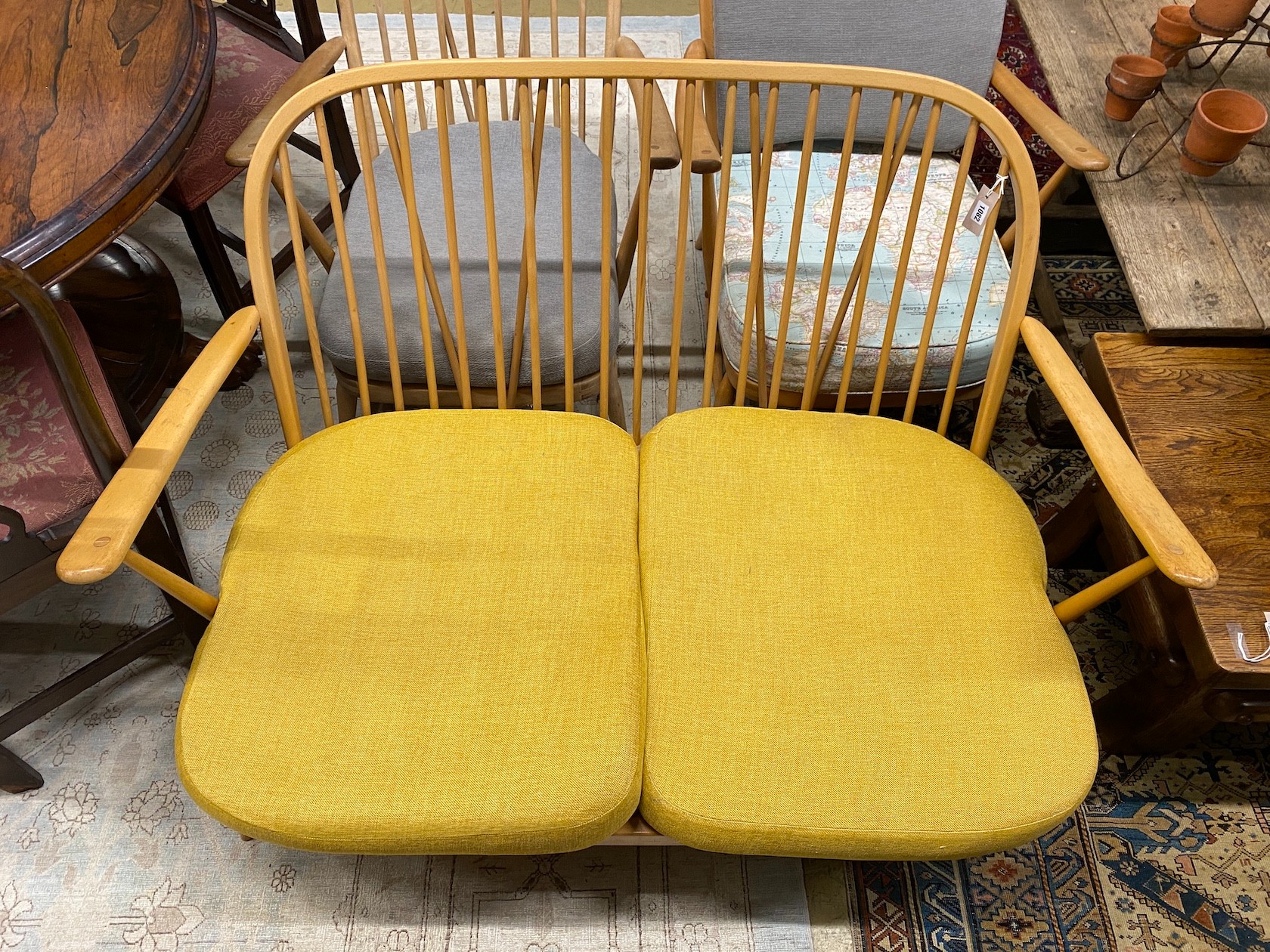 A mid century Ercol light beech three piece lounge suite, lacks three back cushions, settee length 133cm, depth 76cm, height 78cm